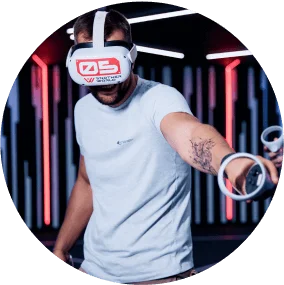 A man wearing VR glasses with his hand extended forward.